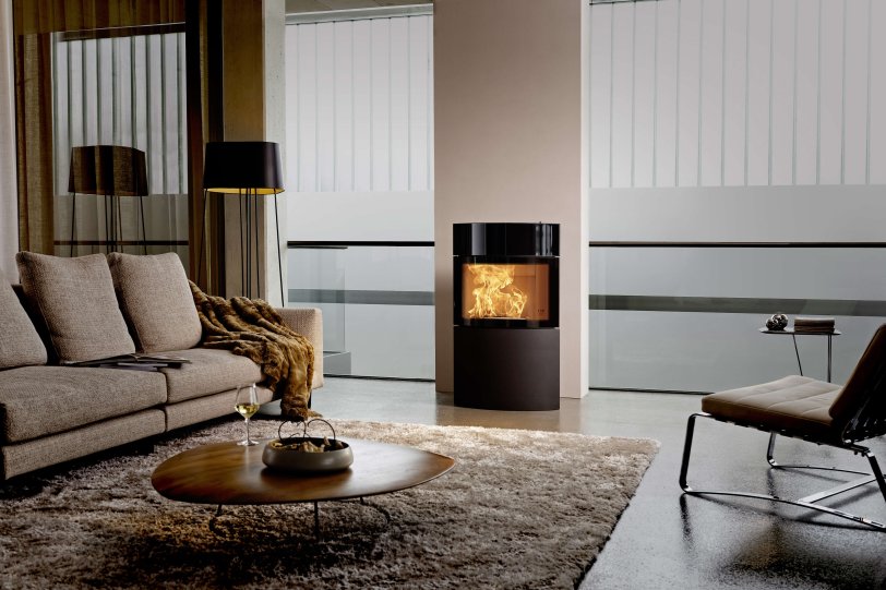 Fynn Xtra stove ambiance photo with black glass- and steel cladding in living room