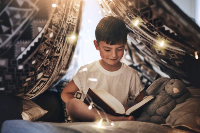 Enfant avec livre sous des lumières