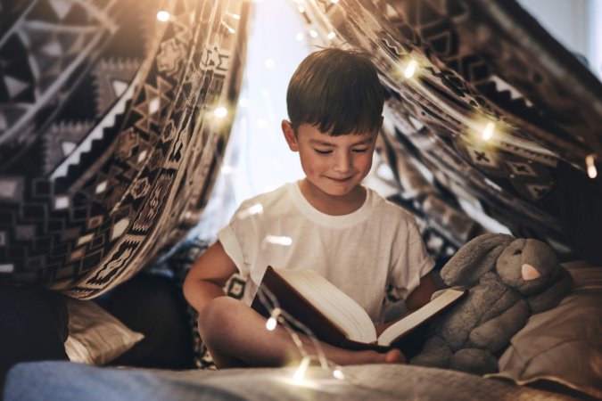 Child with book under lights Child with book under lights