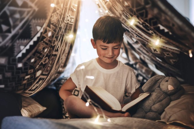 Kind mit Buch unter Lichtern